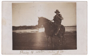 Postcard, with a photo of a man on a horse, in front of a flooded plain (1910)