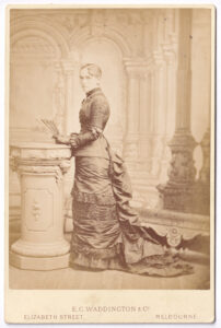 Cabinet card, with a photograph of a woman, from the late 19th century